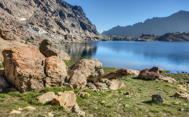 Fototapeta na wymiar Rocky Alpine Lake on Sunny Summer Afternoon