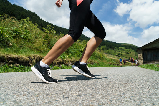 Crop woman jogging in countryside