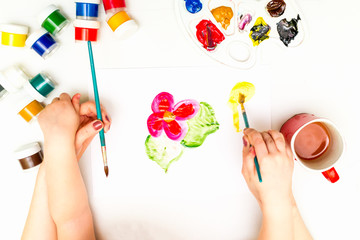 Child's hands painting a flower