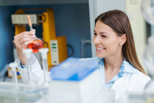 Woman scientist carrying out experiment in research laboratory