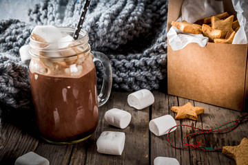 Fototapeta na wymiar Traditional autumn winter drinks and treats. Cup of hot chocolate with marshmallow and ginger biscuit stars, in gift box, old rustic wooden table. Cozy atmosphere, copy space