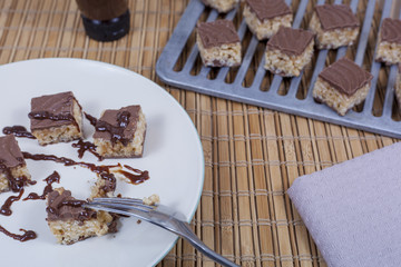 Plate of caramel bites being covered in chocolate sauce