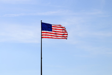 United States of America flag with cloudy blue sky