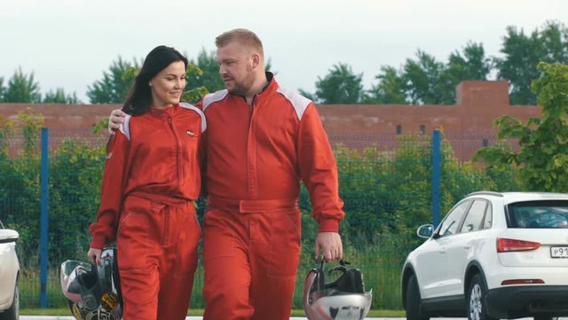 loving couple in red racing suits go to the race
