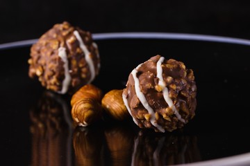 Nut and chocolate praline on elegant black plate