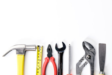 Top view of Working tools,wrench,socket wrench,hammer,screwdriver,plier,electric drill,tape measure,machinist square on white background. flat lay