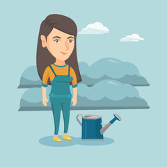 Young cheerful caucasian farmer standing near watering can on the background of agricultural field with bushes. Smiling farmer watering plants in the garden. Vector cartoon illustration. Square layout