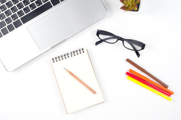 laptop computer, blank spiral notebook with pencil, color pen and glasses on white background
