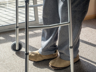 Legs and feet of a senior man using a walker