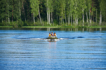 Children in motor boat swim on lake