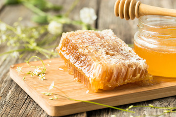 Honeycomb on wooden board with honey spoon
