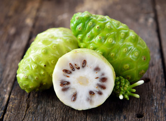 noni fruit on wooden background