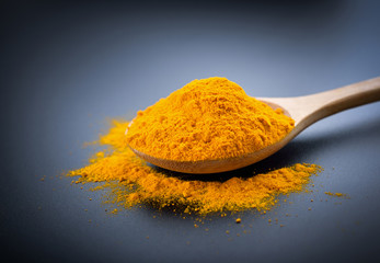 Turmeric powder on black background.