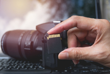 Photographer's hand holding memory card for preparing his camera before photography.