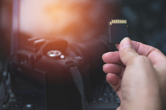 Photographer's hand holding memory card for preparing his camera before photography.