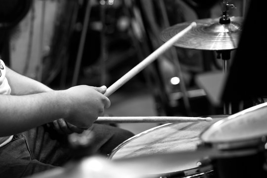  Human hands playing the drum kit in black and white