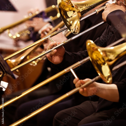 "Trombones in the hands of musicians in the orchestra closeup" Stock