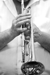 Obraz premium Hands of a musician playing on a trumpet closeup in black and white tones