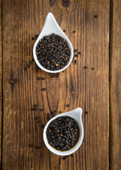 Black Peppercorns, preserved, on wooden background