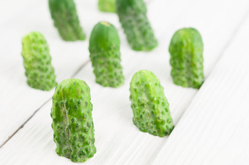 Lot of half of green fresh cucumbers on rustic white wooden planks
