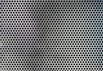 Sheet of metal covered with lines of circular holes Background