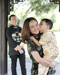 middle aged of Chinese family in Chinese black outfit at the park in summer .