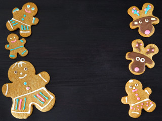 Fototapeta premium Dark New Year background. Gingerbread men and deers are framing empty place for a text