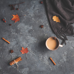 Autumn composition. Cup of coffee, blanket, autumn leaves on black background. Flat lay, top view, square