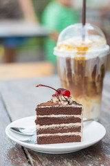 chocolate cake with cherry topping and ice coffee mocha in outdoor cafe