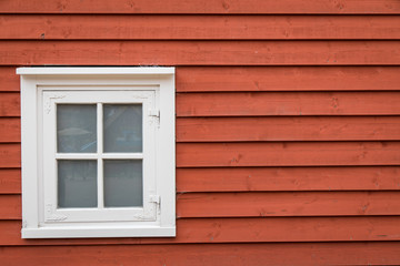 Rote Holzwand mit Fenster und Textfreiraum