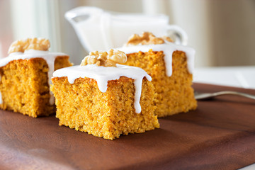 Piece of homemade carrot cake with nuts and icing cream. Selective focus. Close up.