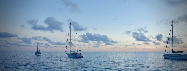 Panorama Segelboote vor Anker im Sonnenuntergang - obrazy, fototapety, plakaty