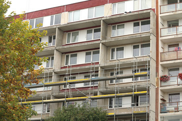Old socialistic house of flat (prefabricated panel house) under reconstruion of its exterior and adding balcony to each apartment, scaffolding under construction © ravennka