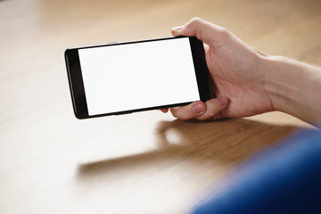 young man hand holding smartphone with blank white screen