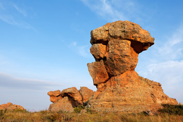 Sandstone rock formation against a blue sky and clouds, South Africa.