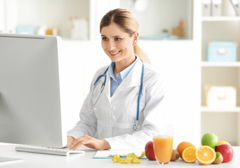 Young female nutritionist working in her office