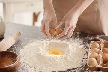 Female chef making dough in kitchen