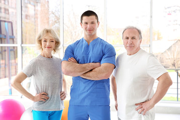 Fototapeta premium Physiotherapist with elderly patients in modern clinic