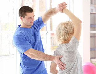 Obraz premium Physiotherapist working with elderly patient in clinic