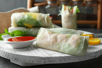 Delicious spring rolls on wooden board
