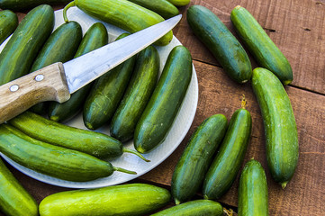 To make cucumbers, cut cucumbers with knife and make salad,Natural and organic tomatoes and cucumbers to consume and human health, natural vegetables
