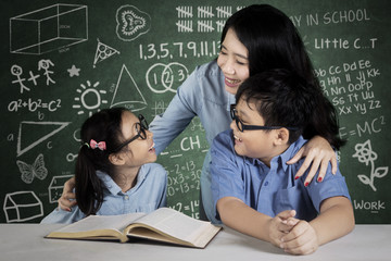 Two students studying together with their teacher