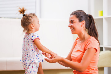 Happy mother and daughter having nice time in their home.