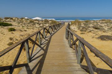 Wooden walkway giving access to the beach of La Barrosa in Sancti Petri, Cadiz, Spain.