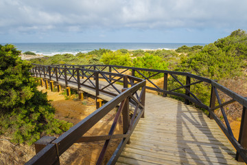 Wooden walkway giving access to the beach of La Barrosa in Sancti Petri, Cadiz, Spain.