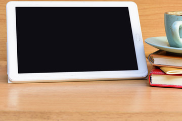 Tablet computer with notebook and cup coffee on notebook on table