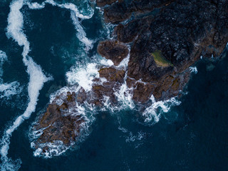 Aerial shot of waves hitting rocks on ocean coast - 167653290