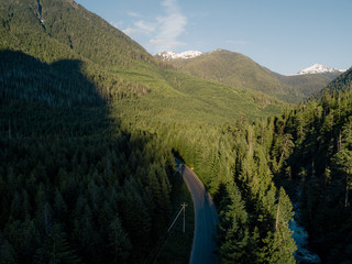 Aerial shot of road in valley while sunset behind mountain