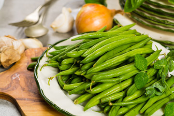 Fresh green snap beans on the plate ready to cook