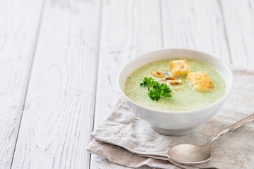 Green healthy cream soup with  broccoli, crackers, cashew, parsley. Copy space